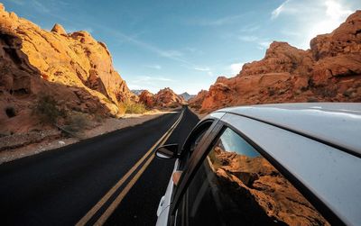 Road amidst rocky mountains against sky