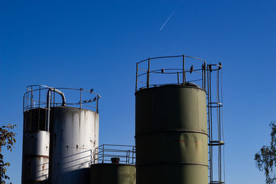 Low angle view of factory against blue sky