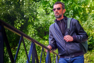 Portrait of man standing by railing