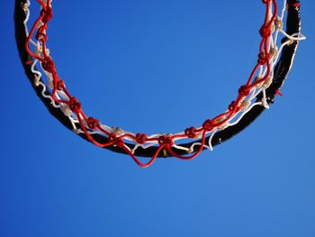 Low angle view of chain swing ride against clear blue sky