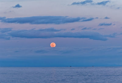 Scenic view of sea against sky at dusk and moon rise