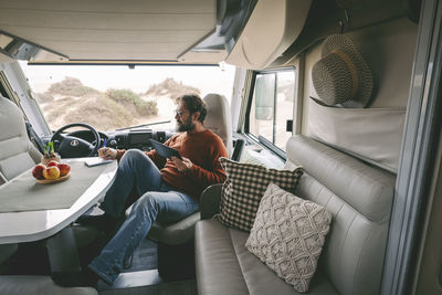 Man with tablet pc sitting in motor home