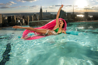 Happy bikini woman on pool raft enjoying in swimming pool