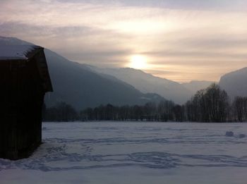 Scenic view of snow covered mountains against sky during sunset