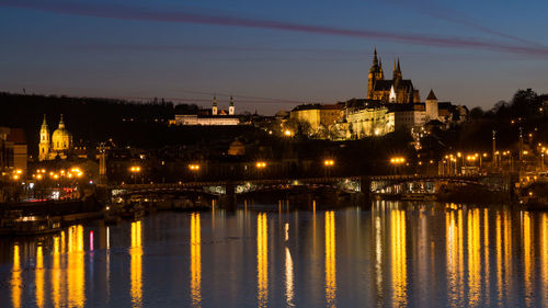 View of illuminated bridge over river at night