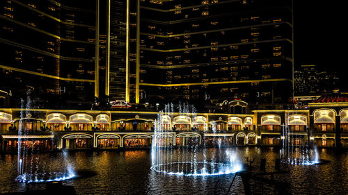 Reflection of illuminated building on glass at night