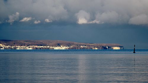 Scenic view of sea by buildings against sky