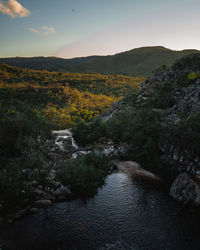 Scenic view of river amidst trees against sky during sunset