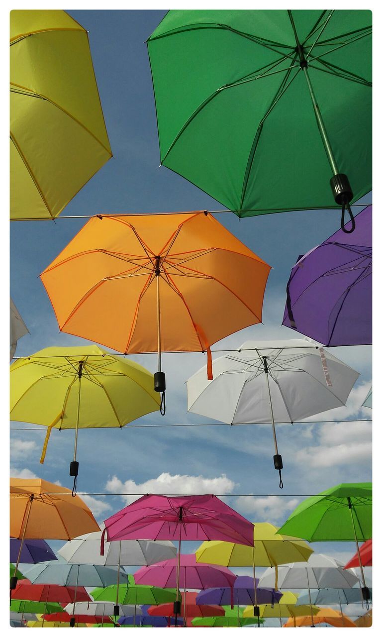 multi colored, umbrella, low angle view, colorful, pattern, protection, yellow, day, sky, hanging, parasol, auto post production filter, creativity, outdoors, design, mid-air, transfer print, art, decoration, clear sky