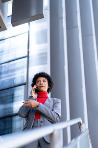 A young african-american businesswoman wearing a red turtleneck and a suit in a business building