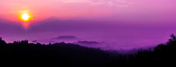 Scenic view of silhouette mountains against sky at sunset