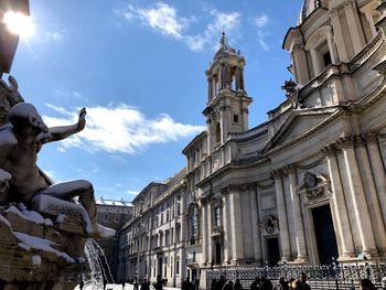 Low angle view of statue against buildings in city