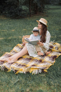 Young woman with son sitting on grass