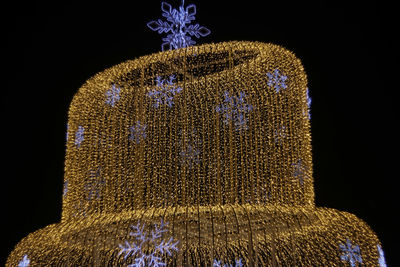 Close-up of illuminated statue against black background