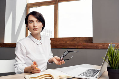 Businesswoman looking away while sitting at home