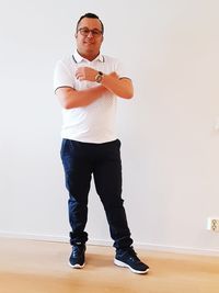 Portrait of young man standing against wall