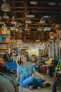 Full length portrait of woman sitting in amusement park