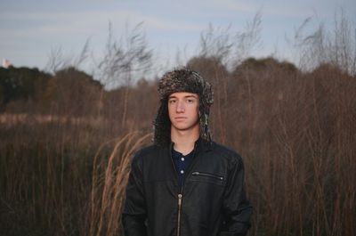 Portrait of confident young man standing on field