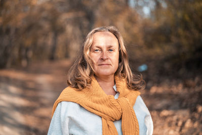 Portrait of woman standing by tree during winter