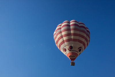 Low angle view of hot air balloon against clear blue sky