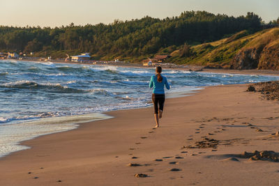 Young sporty girl running on beach