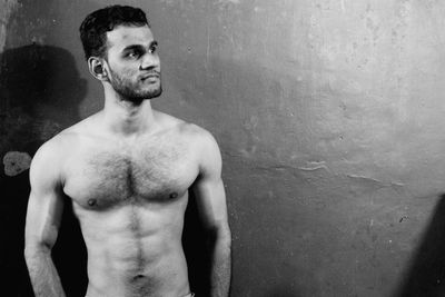 Portrait of young man standing against wall