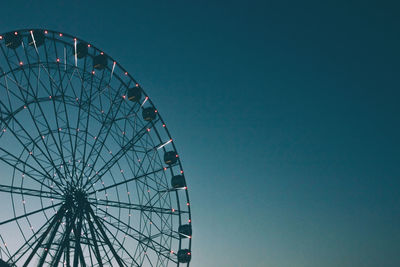 Glowing lights on the ferris wheel, resort nightlife, background, beautiful sky. high iso, grain