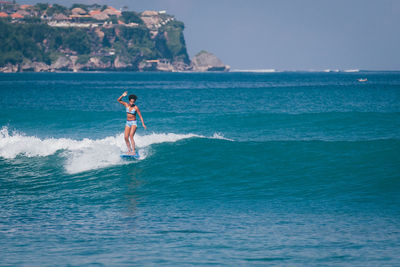 Full length of woman surfing in sea