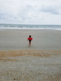 Scenic view of beach against cloudy sky