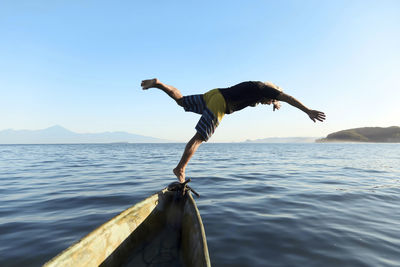 Man jumping from boat into sea