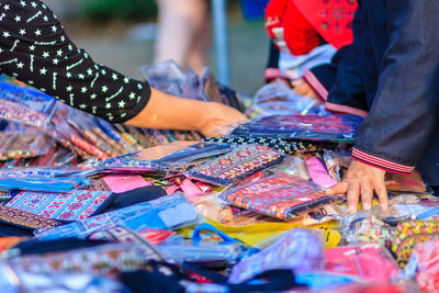 Cropped image of woman choosing wallets at market