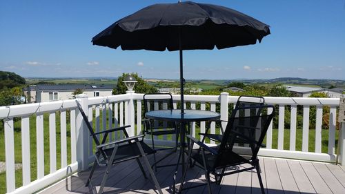 Close-up of table and chairs against sky