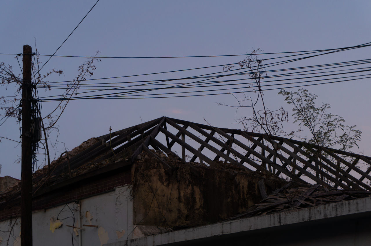 LOW ANGLE VIEW OF ELECTRICITY PYLON ON ROOF AGAINST SKY