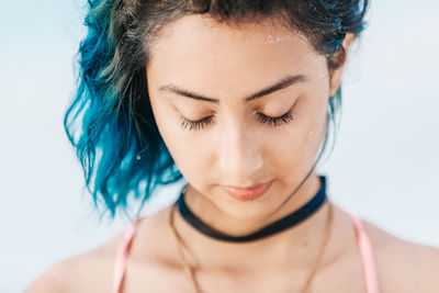 Close-up of young woman against white background