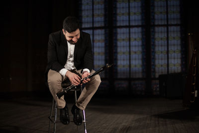 Young man sitting on guitar