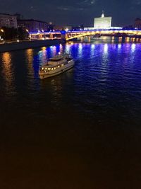 Illuminated bridge over river at night