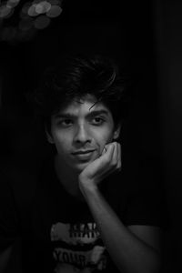 Portrait of young man against black background