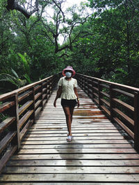 Rear view of woman walking on footbridge