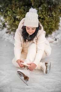 Rear view of woman sitting on snow