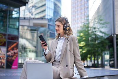 Businesswoman using mobile phone in city