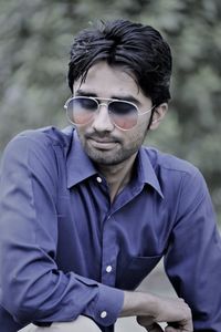 Portrait of young man wearing sunglasses standing outdoors