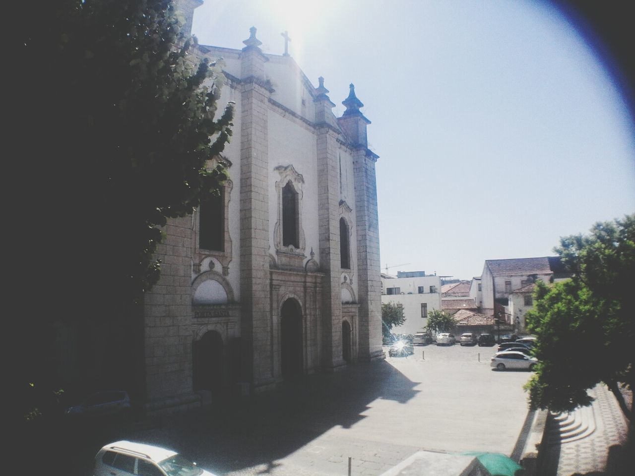 architecture, building exterior, built structure, religion, church, spirituality, place of worship, tower, car, arch, land vehicle, clear sky, travel destinations, outdoors, day, history, sky, tall - high, facade, no people