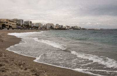 Scenic view of beach and buildings against sky