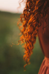 A girl with red curly hair. long hair