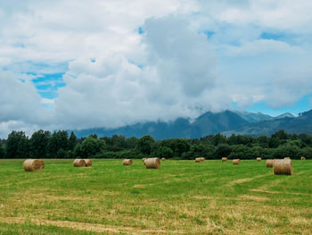 Hay bales on field against sky