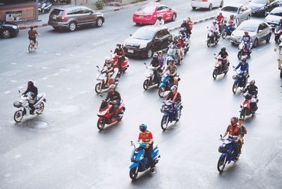 High angle view of people riding land vehicles on street