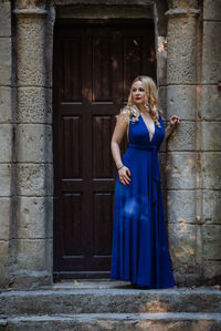 Portrait of woman standing against brick wall