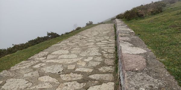 Footpath by road against sky