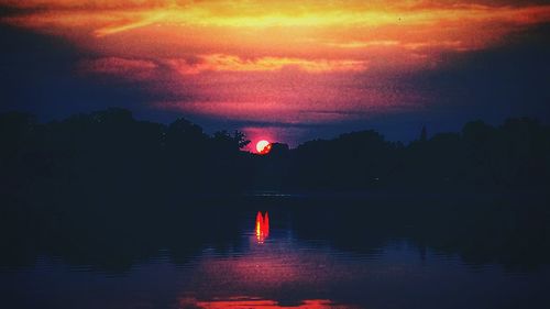 Reflection of clouds in sea at sunset