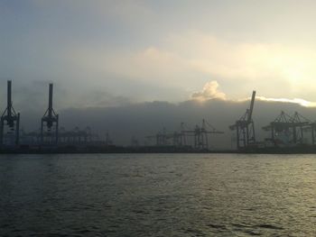 Silhouette of cranes at harbor